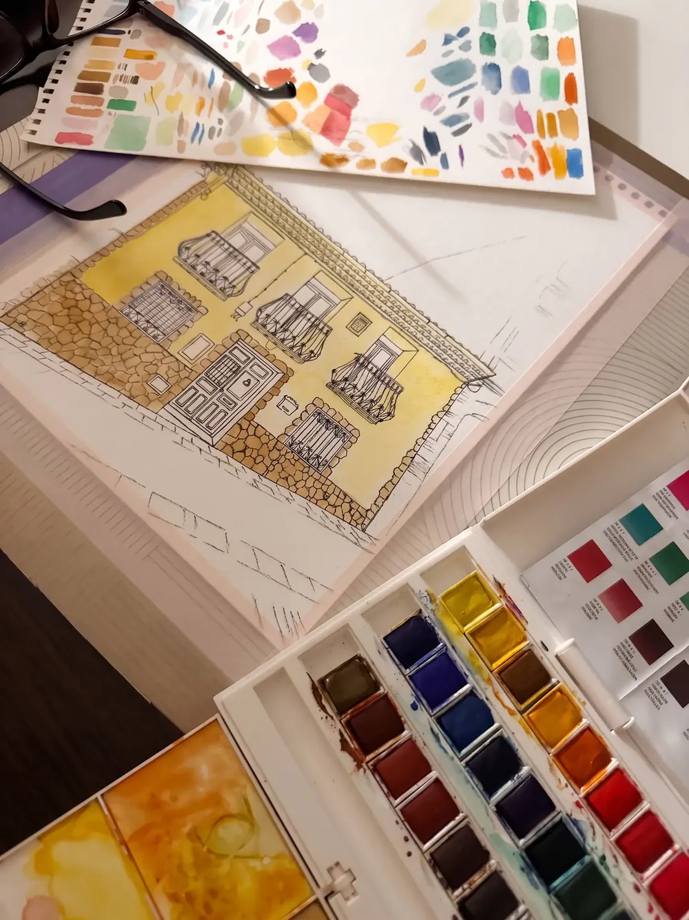 Capas de color de acuarela aplicadas sobre el boceto a tinta de la casa de pueblo
