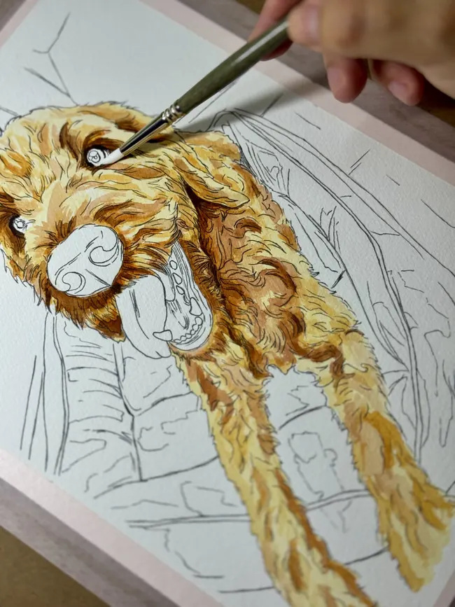 Retrato de mascota en acuarela a medio pintar, con el pincel sobre el papel