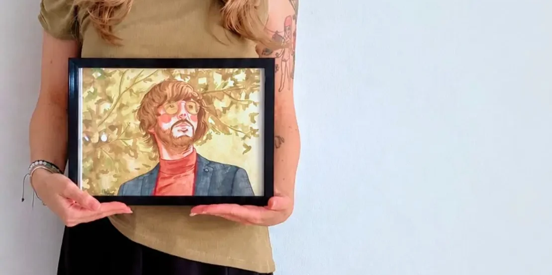 Cliente sosteniendo su retrato en acuarela personalizada, encargo terminado y entregado